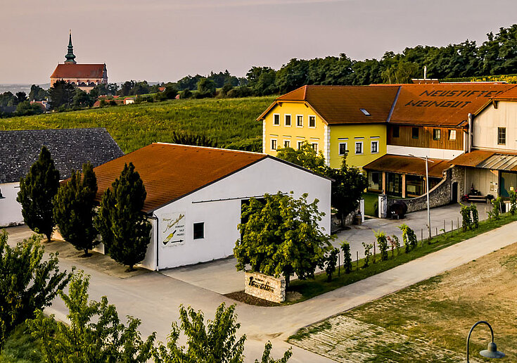 Weingut Neustifter Das Wein.Gut Neustifter befindet sich inmitten der Weingärten. Das Bild wurde im Herbst aufgenommen. Im Hintergrund kann man die Stadtpfarrkirche von Poysdorf erkennen.